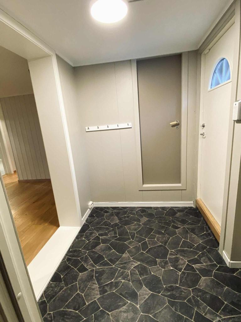 Gang med dør inn til stor bod.